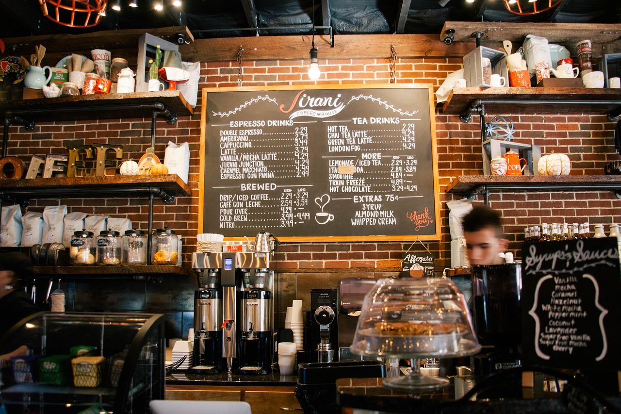 A coffee shop counter with an espresso machine and a menu board